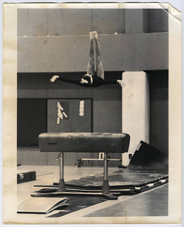 Young woman performing a jump from a pommel horse · heritage